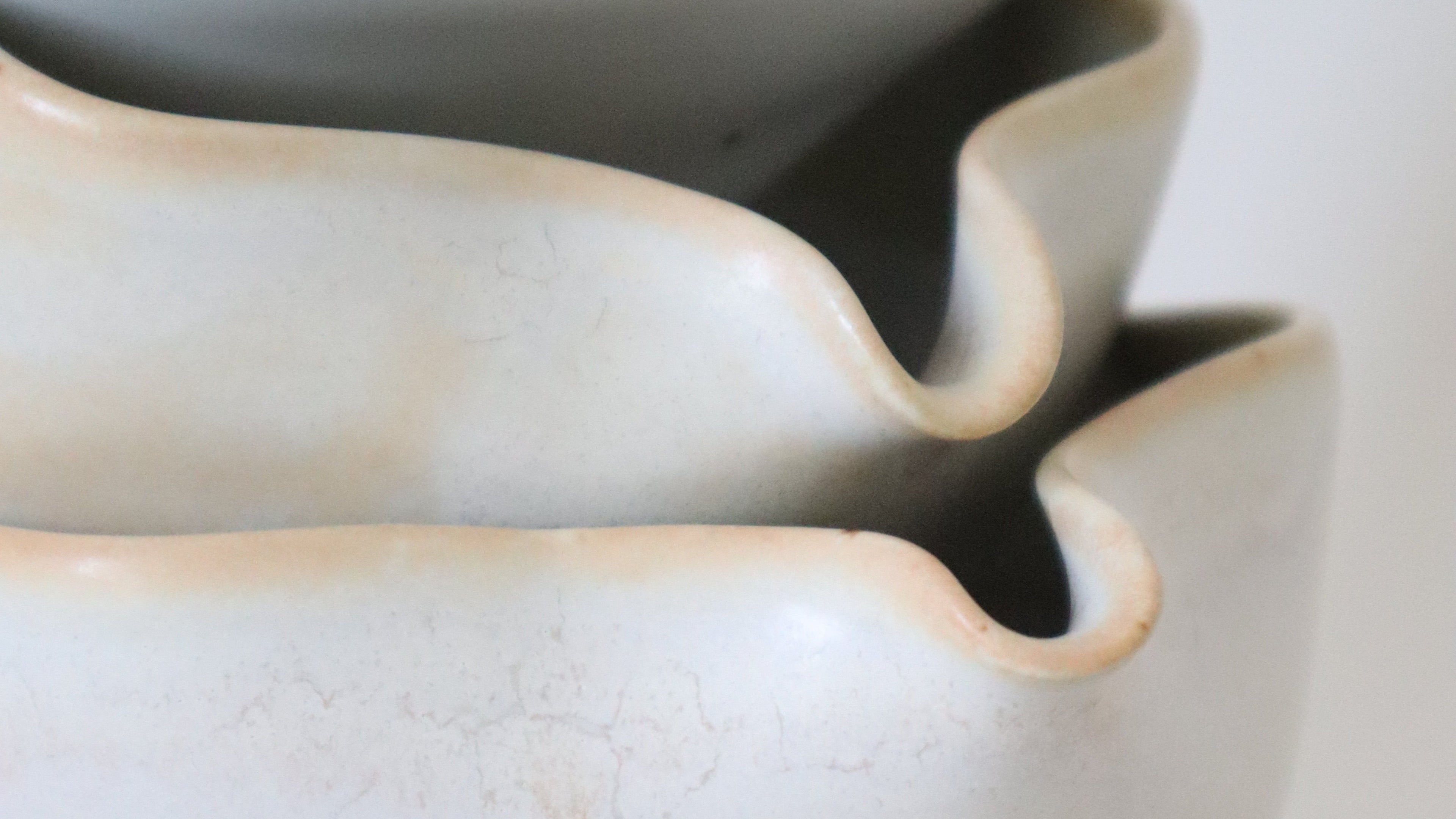 Close-up of a ceramic vase with a textured surface on a light background