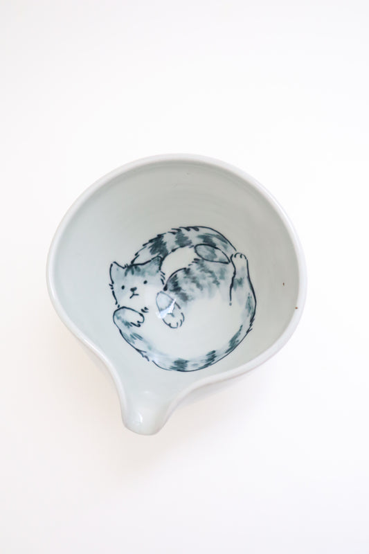 White ceramic dish with a blue cat illustration on a white background