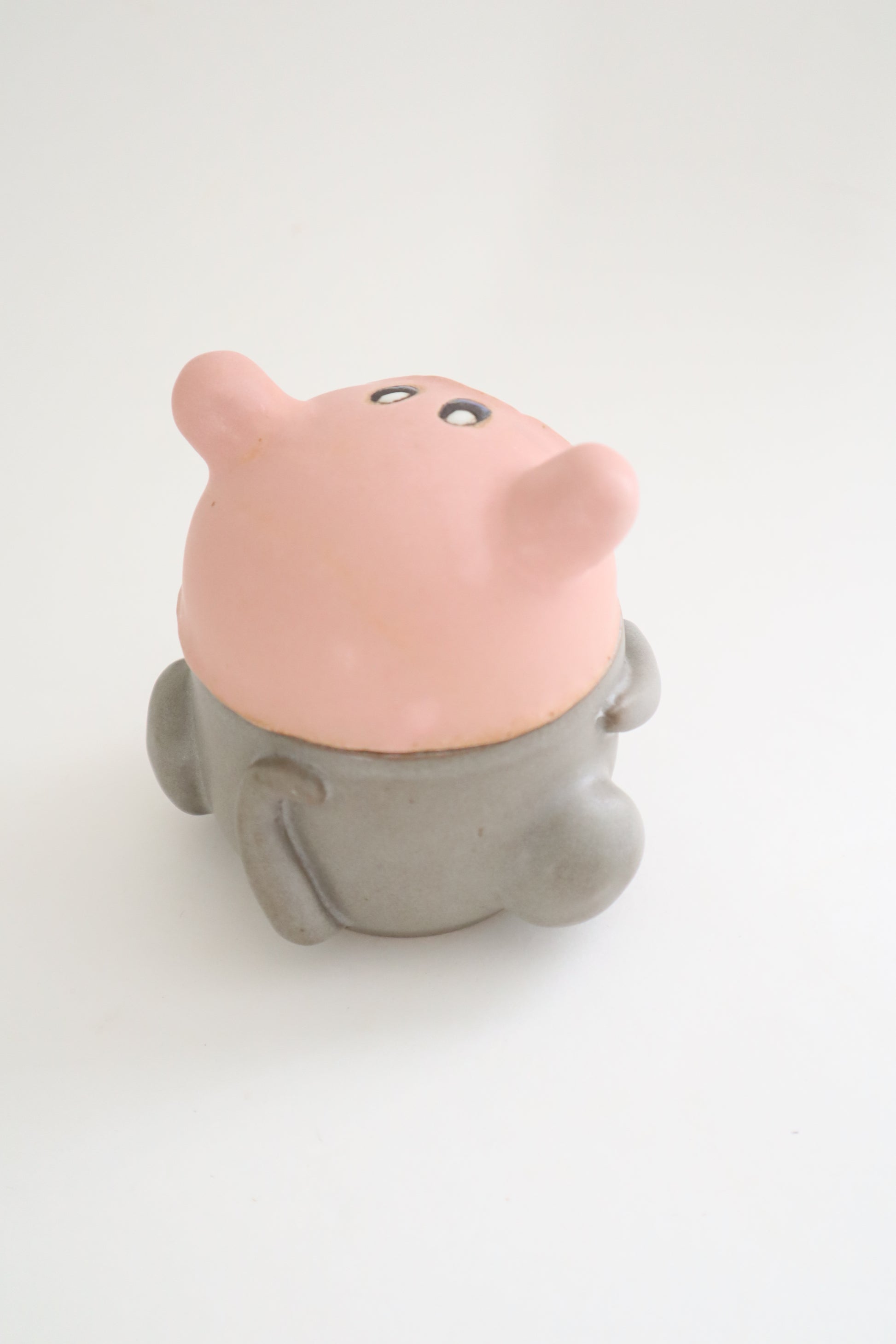 Small cat in kirby hat jar with a gray base on a white background